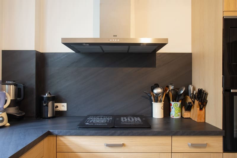 Cuisine façade bois et crédence noire en L à Blois | Raison Home